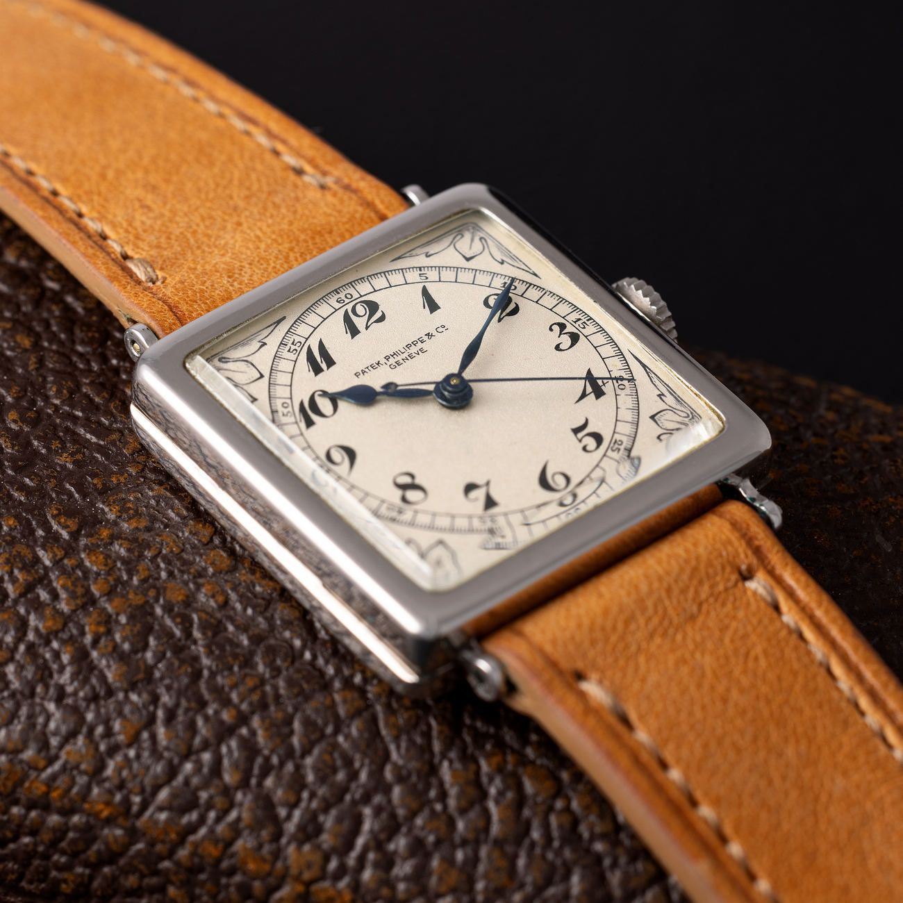 Lot 208 – Possibly unique platinum Square Shape wristwatch from the late 1920s, featuring a center-second movement and a large, hinged case with dial displaying black enamelled “Breguet” numbers and Art-Deco decorations.