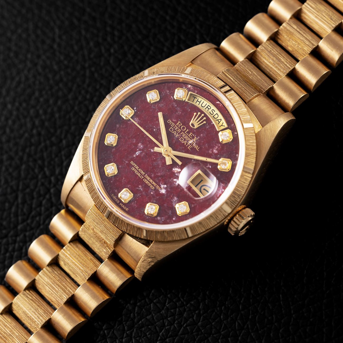 Lot 153 – Bark finish Day-Date in yellow-gold reference 18 078, with diamond-set rubellite dial. 