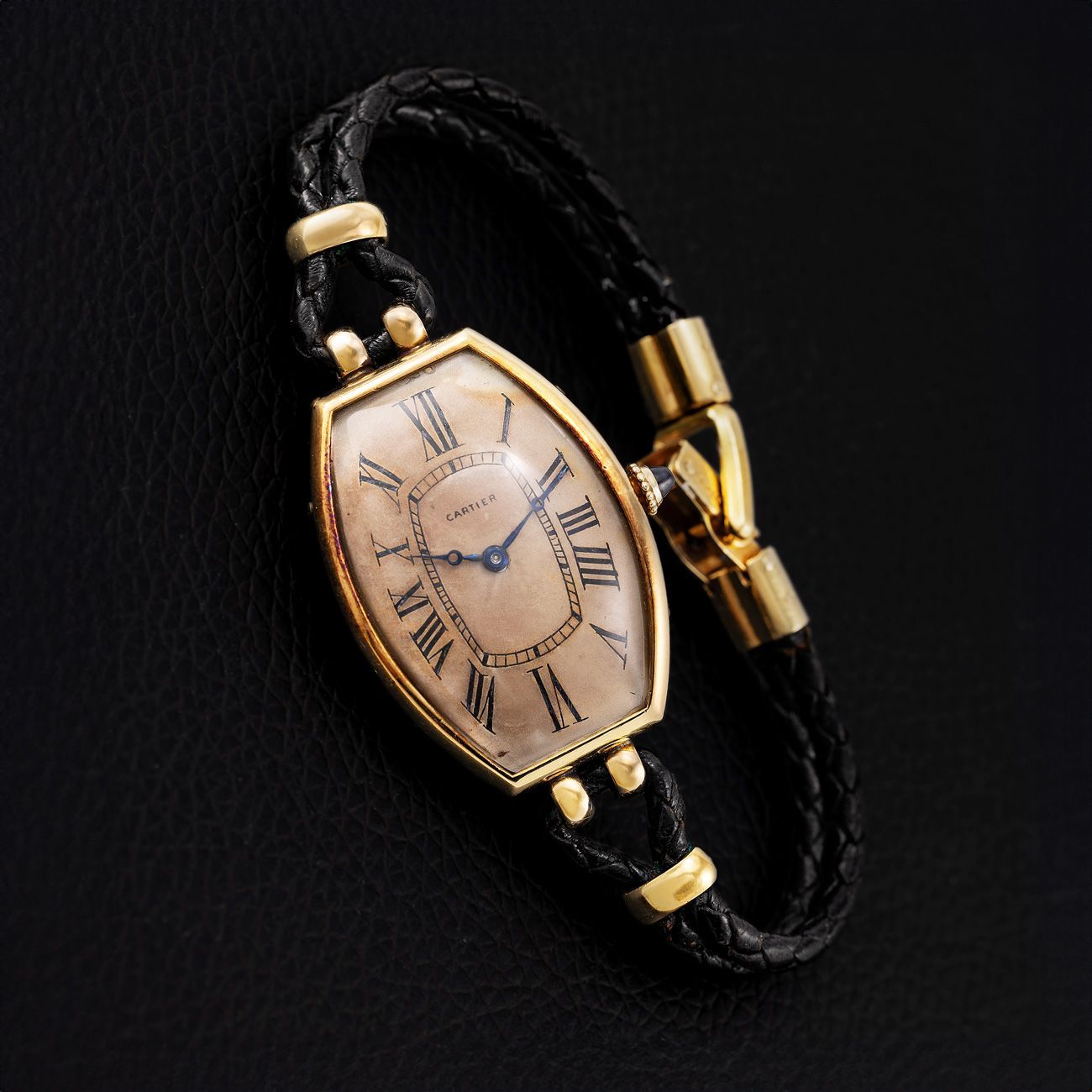 Cartier Tonneau, Yellow Gold (1925)A rare and historic 1928 Cartier Tonneau in yellow gold, featuring a distinctive elongated shape and tropical Roman numeral dial. Accompanied by a copy of the Cartier archives, this well-preserved piece captures the elegance and innovation of 1920s design.