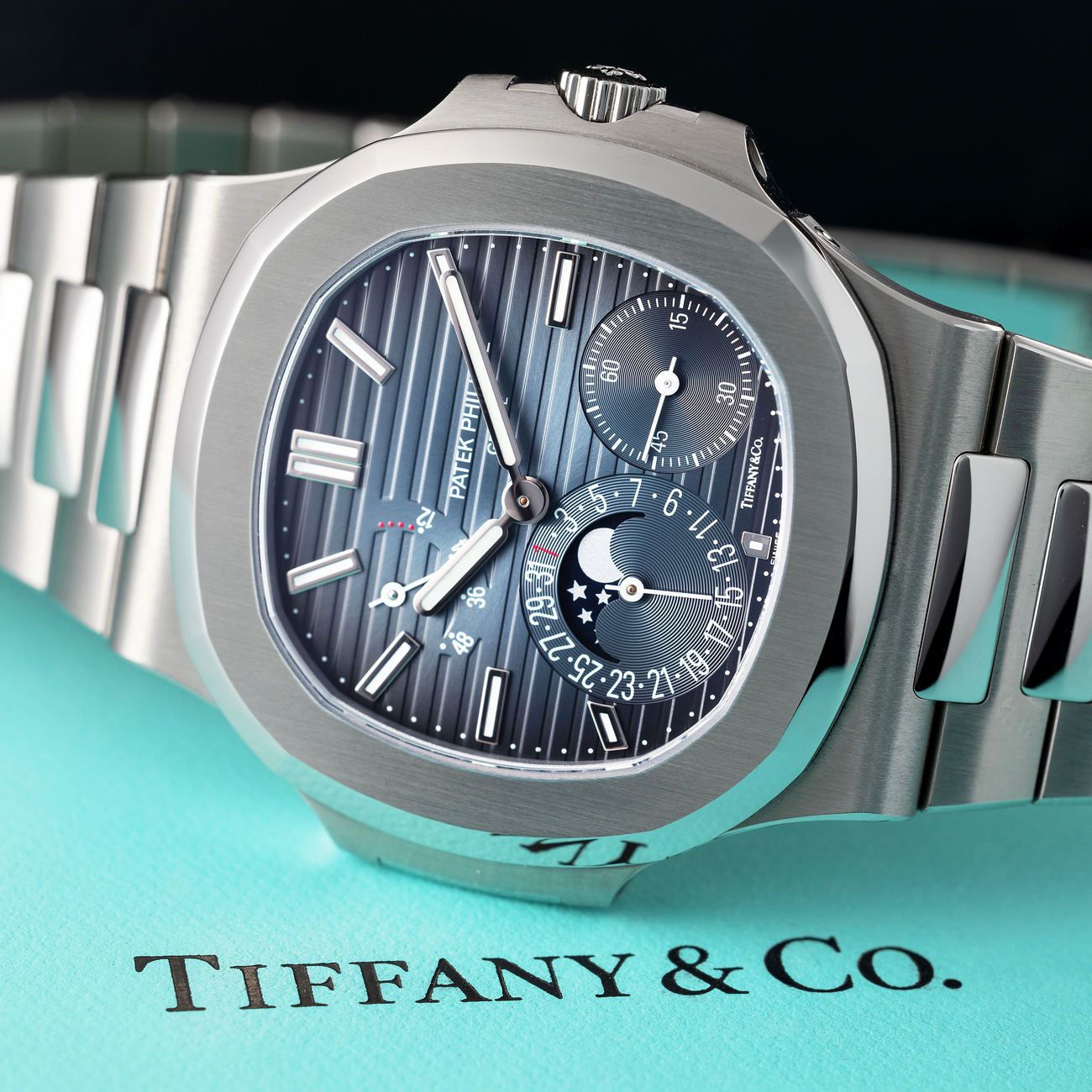 Lot 164 — Patek Philippe Nautilus in steel reference 5712/1A. Retailed by Tiffany & Co, with box, booklets and certificate of origin – View Lot