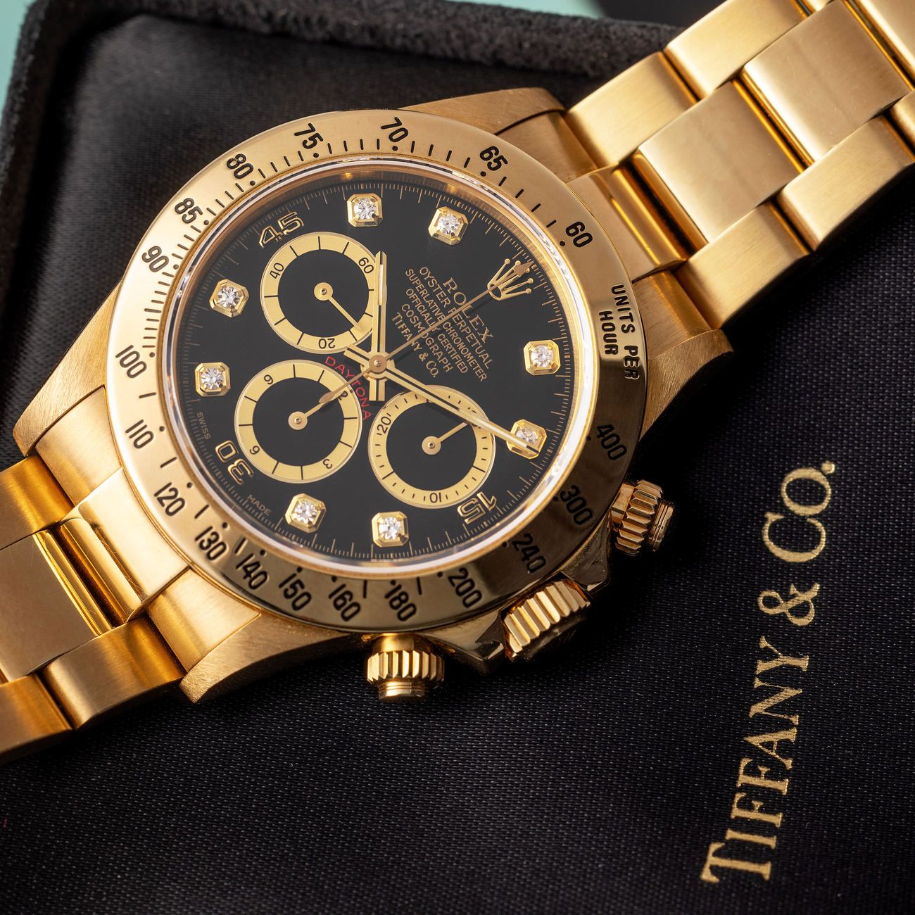 Lot 214 — Rolex Perpetual Daytona chronograph in yellow gold, reference 16 528, with black diamond-set dial. Retailed by Tiffany & Co with box and warranty – View Lot