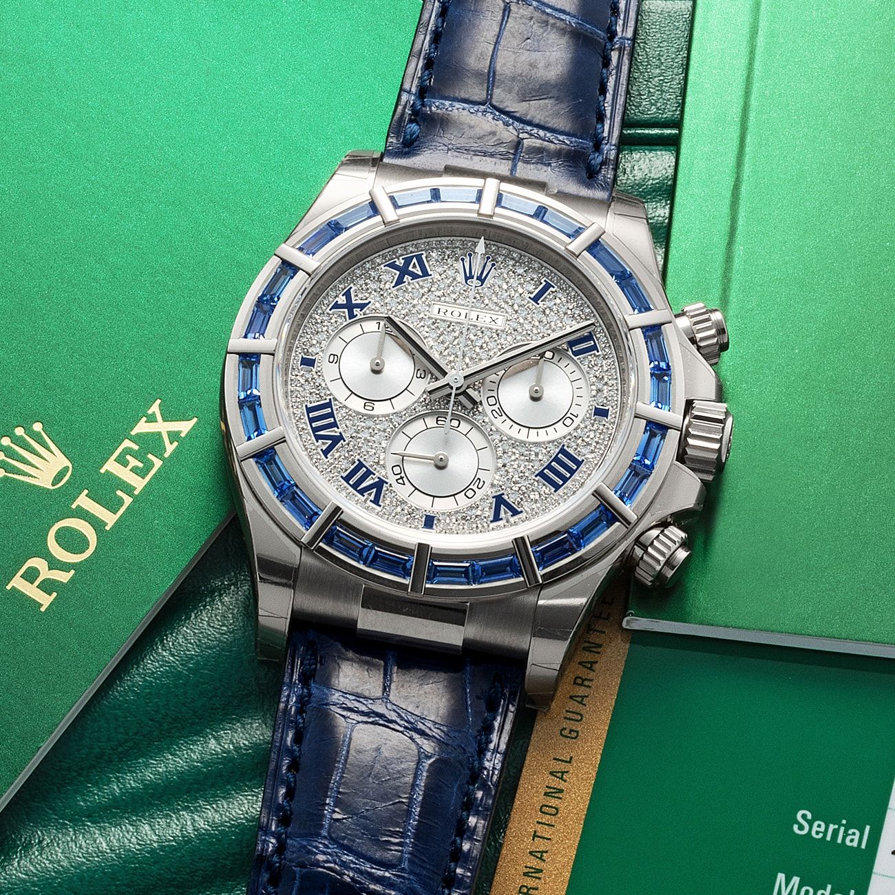 Lot 8 - Highly Exclusive, Very Impressive and Attractive, Daytona, Automatic Chronograph Wristwatch, in White Gold, Full Diamond-Pavè, Blue Enamel Roman Number Dial and Rare Sapphire-Set Bezel, Reference 116589SACI, With Box and Papers – Estimate: € 120,000 – 240,000 – View lot detail